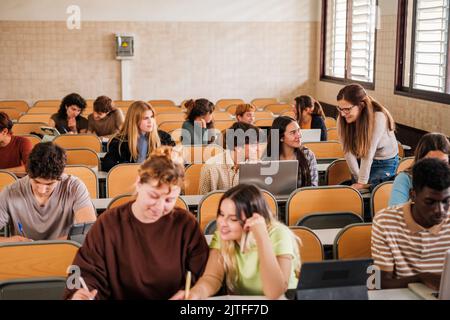 Lehrer erklärt den Schülern individuell, während sie arbeiten. Konzentrieren Sie sich auf den Lehrer Stockfoto