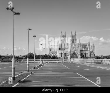 Erhöhter Blick vom Asphalt auf den alten Münster, Kirche, unter hellblauem Himmel mit Wolken im Frühling in Beverley, Yorkshire, Großbritannien. Stockfoto