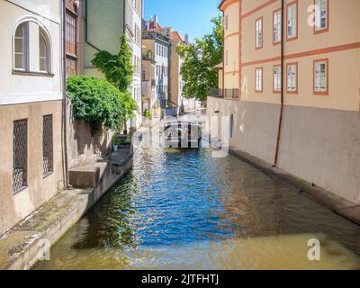 Prag, Tschechische Republik - Juni 2022: Boot mit Touristen auf dem Kanal Čertovka im Zentrum von Prag. Stockfoto