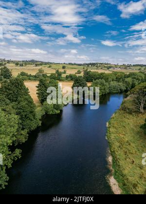 Eine vertikale Aufnahme, Luftaufnahme des Flusses Wharfe im Wharfe-Tal mit blauem Himmel und vereinzelten Wolken. Stockfoto