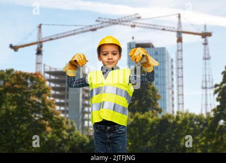 Kleiner Junge, der Macht über die Baustelle zeigt Stockfoto