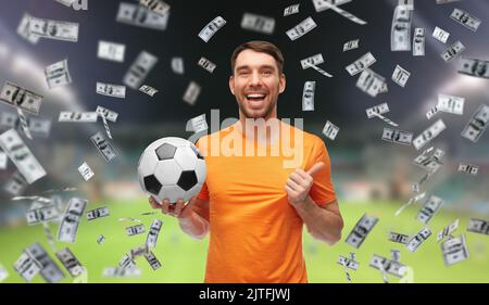 Glücklicher Mann mit Fußball über Geld Stockfoto