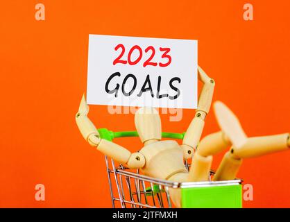Symbol für 2023 Tore. White Paper mit den Worten 2023 Ziele, menschliches Modell im warenkorb. Schöne orange Tisch orange Hintergrund. Business und 2023 Ziele conce Stockfoto