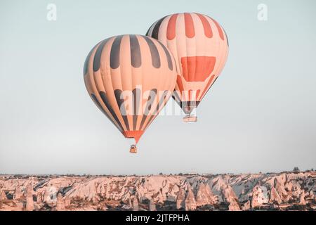 Zwei bunte Heißluftballons fliegen über die Landschaft des Kappadokien-Goreme-Tals mit Steinhöhlen. Die beste berühmte Reisestelle in der Türkei. Beliebte Touristenattraktion. Erstaunliche natürliche Sommerlandschaft Stockfoto