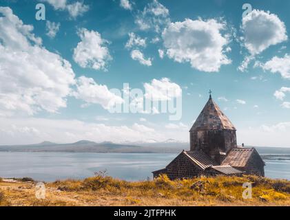 Sevanawank Klosterkomplex am Sevan See, Provinz Gegharkunik, Armenien. Schöne alte Architektur Kirche unter blauem Himmel mit flauschigen Wolken. Naturlandschaft. Beliebtes touristisches Reiseziel. Stockfoto