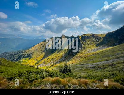 Grüne Bergkette Gipfellandschaft unter hellblauem Himmel. Wunderbare Sommerszene. Atemberaubender natürlicher Hintergrund. Beliebtes Touristenziel. Reisen, Wandern, Klettern. Karpaten, Ukraine Stockfoto