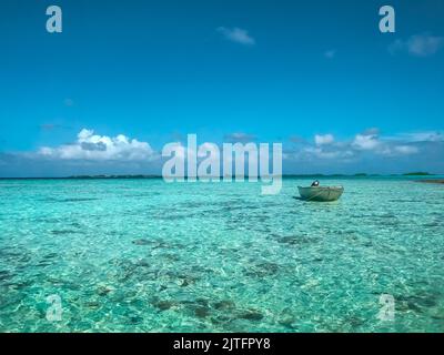 Türkisfarbenes Meerwasser Insellandschaft. Blauer Himmel und Fischerboot. Schöne tropische Strand abstrakte Textur Hintergrund. Exotisches Sommerresort, Urlaub, Paradies Urlaub Reisekonzept. Entspannende Natur Stockfoto