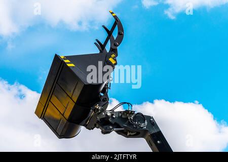 Baggerschaufel aus nächster Nähe am Himmel. Industrielle Baggermaschine, Fokus Auf Baggereimer Stockfoto