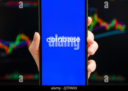 Ukraine, Odessa - Oktober, 9 2021: Coinbase mobile App läuft auf dem Smartphone-Bildschirm mit Trading Candlestick Chart im Hintergrund. Coinbase ist eine amerikanische Kryptowährungs- und Handelsplattform Stockfoto