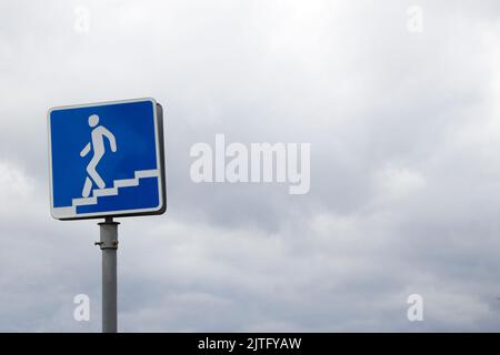 Warnung blaues Straßenschild eines unterirdischen Durchgangs an der Straße mit dem Himmel im Hintergrund am Tag. Stockfoto
