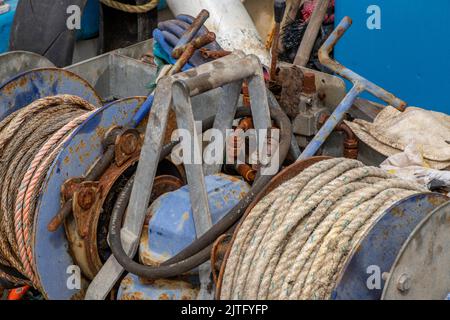 Rostige alte Winde an der Vorderseite eines Offshore-Fischtrawlers, korrodierte Trommelenden an einer mechanischen Winde oder an einem Ankerwinde auf einem Schiff, Angelausrüstung und -Gerät. Stockfoto