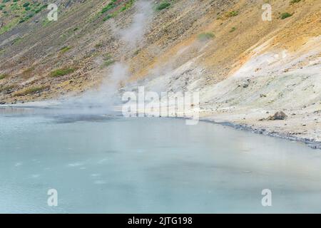 Heißer mineralisierter See mit Thermalquelle und rauchenden Fumarolen in der Caldera des Vulkans Golovnin auf der Insel Kunashir Stockfoto