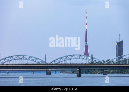 Riga Eisenbahnbrücke mit Fernsehturm im Hintergrund. Stockfoto