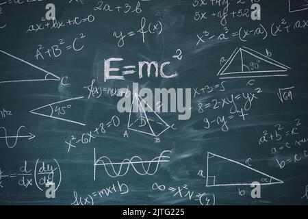 Tafel mit wissenschaftlichen Formeln und Berechnungen in Mathematik eingeschrieben. Wissenschaft und Bildung Hintergrund. Stockfoto