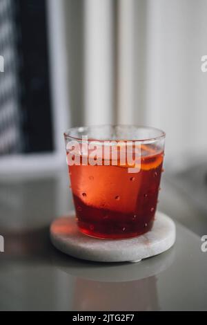 Red Negroni Aperitif-Cocktail in Punktglas auf Marmor-Achterbahn Happy Hour Stockfoto