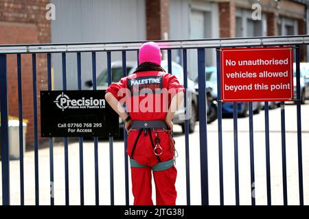 Shepstone, Großbritannien. 30. August 2022. Ein Protestler starrt in das Gelände, während sich Anhänger der Palestine Action mit anderen Protestgruppen zusammentrocken, um vor UAV Engines, Shepstone und Mitarbeitern zu demonstrieren. Das Unternehmen, eine Tochtergesellschaft von Elbit Systems, produziert Drohnen für den Einsatz durch die israelischen Streitkräfte in Gaza und anderswo. Die Demonstranten schlugen drei Zelte direkt vor den Toren auf, um an den Widerstand gegen ihren Waffenhandel zu erinnern. Sie fordern die Schließung der Fabrik. (Foto von Martin Pope/SOPA Images/Sipa USA) Quelle: SIPA USA/Alamy Live News Stockfoto