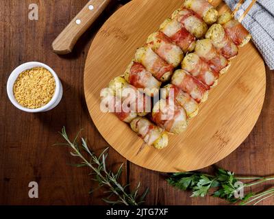 Cassava-Spieße in Speck eingewickelt, Cassava-Medaillon. Stockfoto