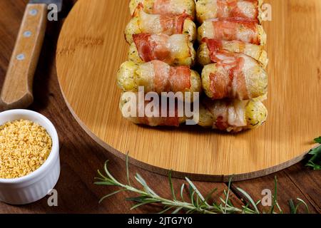 Cassava-Spieße in Speck eingewickelt, Cassava-Medaillon. Stockfoto