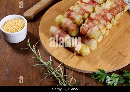 Cassava-Spieße in Speck eingewickelt, Cassava-Medaillon. Stockfoto