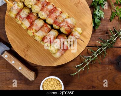 Cassava-Spieße in Speck eingewickelt, Cassava-Medaillon. Stockfoto