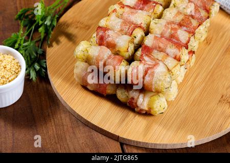 Cassava-Spieße in Speck eingewickelt, Cassava-Medaillon. Stockfoto