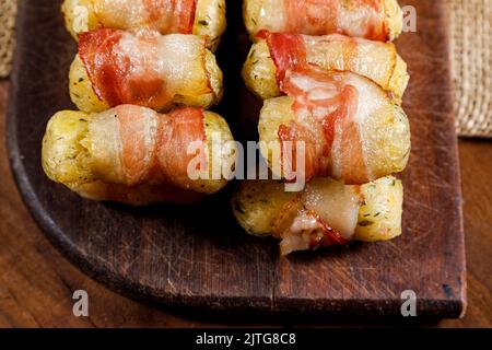 Cassava-Spieße in Speck eingewickelt, Cassava-Medaillon. Stockfoto