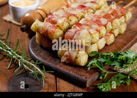 Cassava-Spieße in Speck eingewickelt, Cassava-Medaillon. Stockfoto