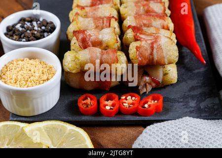 Cassava-Spieße in Speck eingewickelt, Cassava-Medaillon. Stockfoto