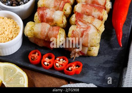 Cassava-Spieße in Speck eingewickelt, Cassava-Medaillon. Stockfoto