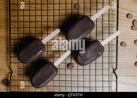 Auf dem Tisch liegen Schokoladen-Cupcakes in Form von Eis. Der Prozess der Herstellung von Cupcakes Stockfoto