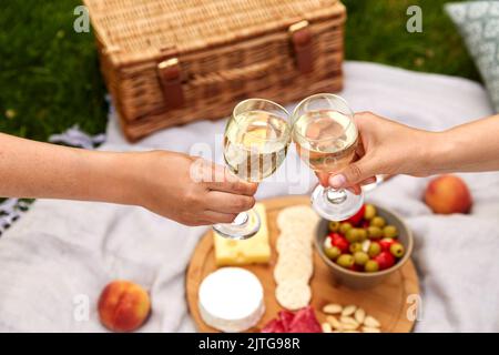 Nahaufnahme der Hände, die beim Picknick Weingläser anklirren Stockfoto