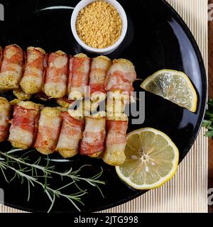 Cassava-Spieße in Speck eingewickelt, Cassava-Medaillon. Stockfoto