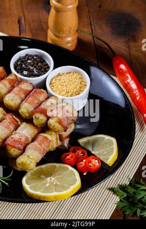 Cassava-Spieße in Speck eingewickelt, Cassava-Medaillon. Stockfoto