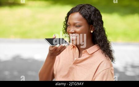 afrikanische Frau, die Stimme auf dem Smartphone aufzeichnet Stockfoto