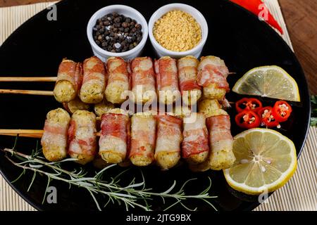 Cassava-Spieße in Speck eingewickelt, Cassava-Medaillon. Stockfoto