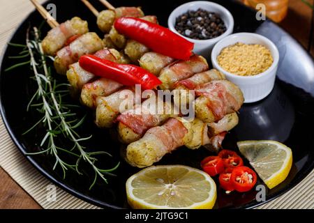Cassava-Spieße in Speck eingewickelt, Cassava-Medaillon. Stockfoto