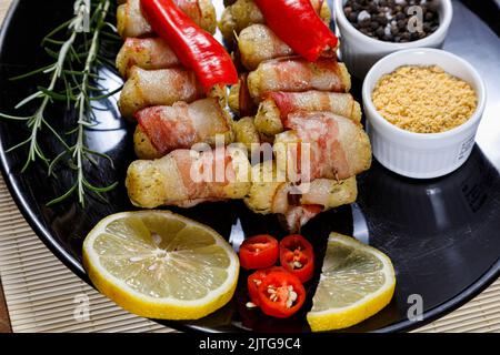 Cassava-Spieße in Speck eingewickelt, Cassava-Medaillon. Stockfoto