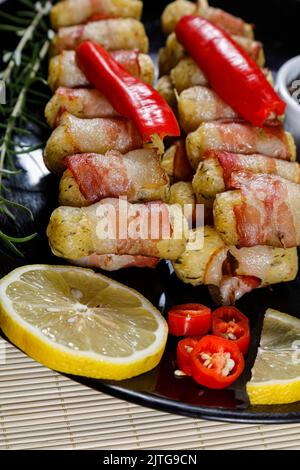 Cassava-Spieße in Speck eingewickelt, Cassava-Medaillon. Stockfoto