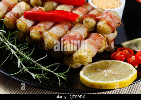 Cassava-Spieße in Speck eingewickelt, Cassava-Medaillon. Stockfoto