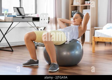 Teenager-Mädchen, die zu Hause auf Übungsball trainiert Stockfoto