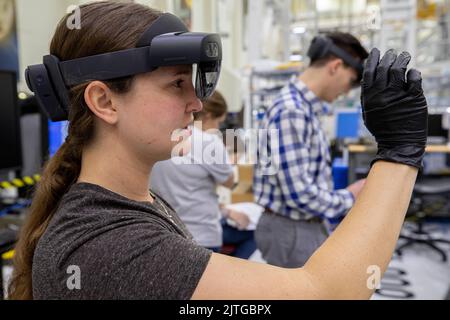 KSC, Florida, USA. 16. Januar 2020. Mary Lakaszcyck, eine Technikerin bei ASRC Federal Data Solutions, demonstriert am 16. Januar 2020 ein Paar Augmented Reality (AR)-Brillen im Hochregal des Neil Armstrong Operations and Checkout Building im NASAs Kennedy Space Center in Florida. Der Orion-Hersteller Lockheed Martin stellte die Brille den Technikern zur Verfügung, um die Klebebänder zu platzieren, wo die Komponenten auf dem Orion-Modul-Adapter für die NASAs Artemis II-Mission, die erste Mission mit Besatzung an Bord des Raumschiffs, installiert werden. Die Verwendung der AR-Brille spart erhebliche Arbeitsaufwand und Zeit für die Ausführung von Aufgaben. Stockfoto