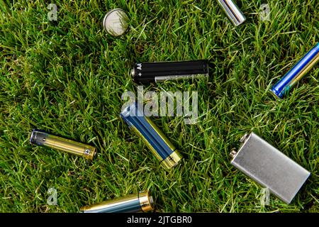 Nahaufnahme von Alkalibatterien auf Gras Stockfoto