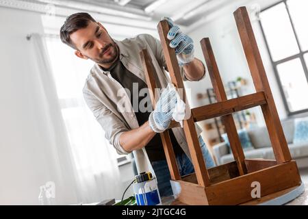 Mann, der die alte Tischoberfläche mit Gewebe reinigt Stockfoto