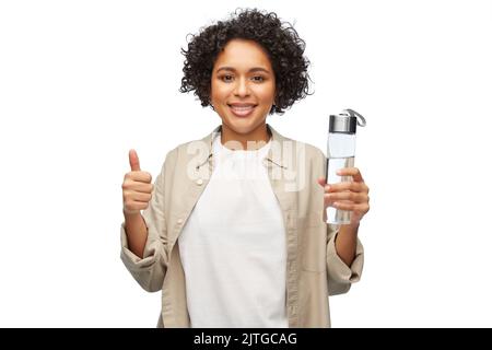 Glückliche Frau mit Trinkwasser in der Glasflasche Stockfoto