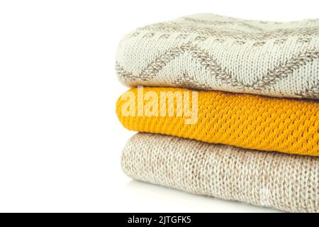 Stapel verschiedener Strickpullover in beige und gelber Farbe isoliert auf weißem Hintergrund mit Platz für Text Stockfoto