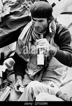 AJAXNETPHOTO. 12TH. APRIL 1974. PORTSMOUTH, ENGLAND. - MEDIENINTERVIEW - FRANZÖSISCHER CO-SKIPPER VON WHITBREAD RUND UM DEN WELTRENNSPORT 33 EXPORT JEAN-PIERRE HIRSE BEIM INTERVIEW MIT FRANZÖSISCHEN MEDIEN ÜBER DIE SICHERE ANKUNFT IN HMS VERNON AM ENDE DER LETZTEN ETAPPE DES RENNENS BEIM GENUSS VON BROT UND WEIN. HIRSE-CO-SKIPPER DOMINIQUE GUILLET WURDE AM 23RD. NOVEMBER 1973 ÜBER BORD VON DER YACHT VERLOREN, NACHDEM YACHT DURCH EINE SCHURKENWELLE IN DEN RAUSCHENDEN VIERZIGER JAHREN N.E. GESTROSTET WURDE DER KERGUELEN-INSELN.FOTO:JONATHAN EASTLAND/AJAX REF:340 220105 30 Stockfoto