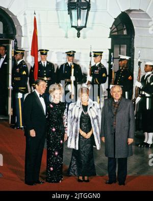 US-Präsident Ronald Reagan, links, und First Lady Nancy Reagan, zweite Linke, begrüßen den Generalsekretär des Zentralkomitees der Kommunistischen Partei der Sowjetunion, Michail Sergejewitsch Gorbatschow, rechts, und seine Frau Raisa Gorbatscheva, rechts Mitte, Zu einem Staatsessen zu ihren Ehren am 8. Dezember 1987 am Diplomatischen Eingang auf der Südseite des Weißen Hauses in Washington, DC.Quelle: Arnie Sachs/CNP/Sipa USA Quelle: SIPA USA/Alamy Live News Stockfoto