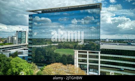 GSK London HQ reflektiert Himmel und Wolken in der Spiegelfassade des Gebäudes Stockfoto