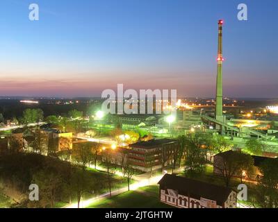 Nächtliche Panoramasicht auf die alte europäische Industriestadt bei Vollmond, lange ausstrahlende Straßen, Nymburk City Stockfoto