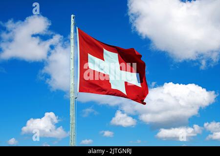 Nationalflagge der Schweiz vor blauem Himmel, Schweiz Stockfoto